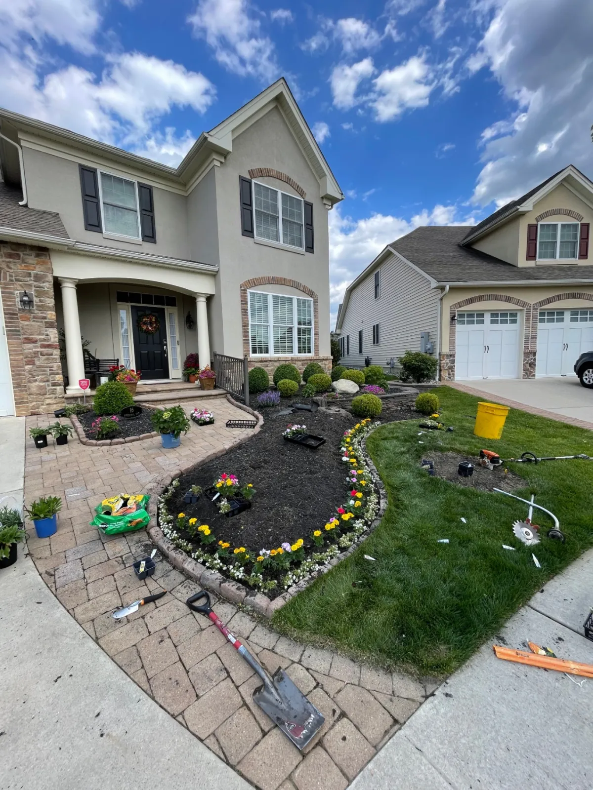 Flowers staged on a driveway before planting